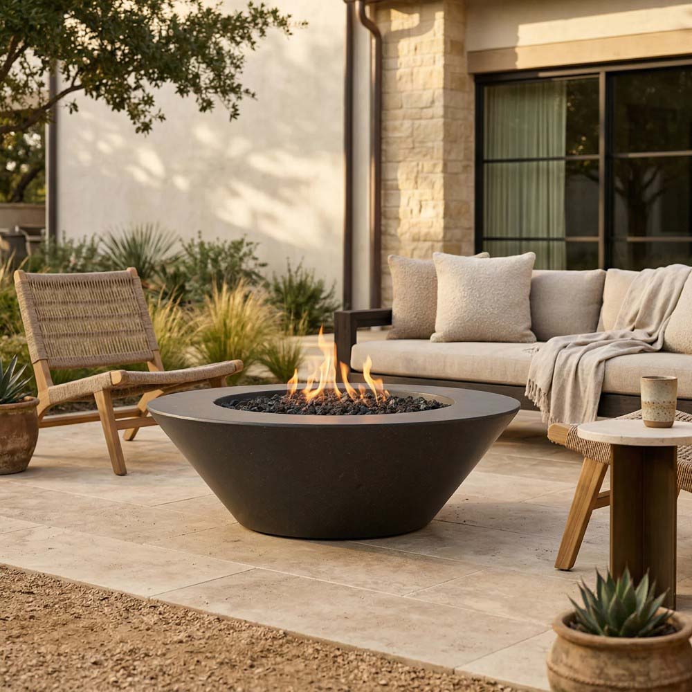 Dark concrete gas fire pit bowl with flame opening and black burner rock bed