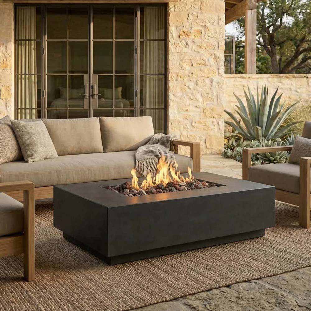 Dark gray rectangular concrete gas fire pit with flames in an outdoor lounge setting