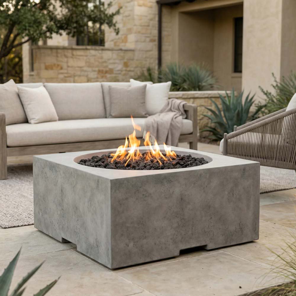 Light-gray concrete square gas fire pit with round burner bowl and open flame