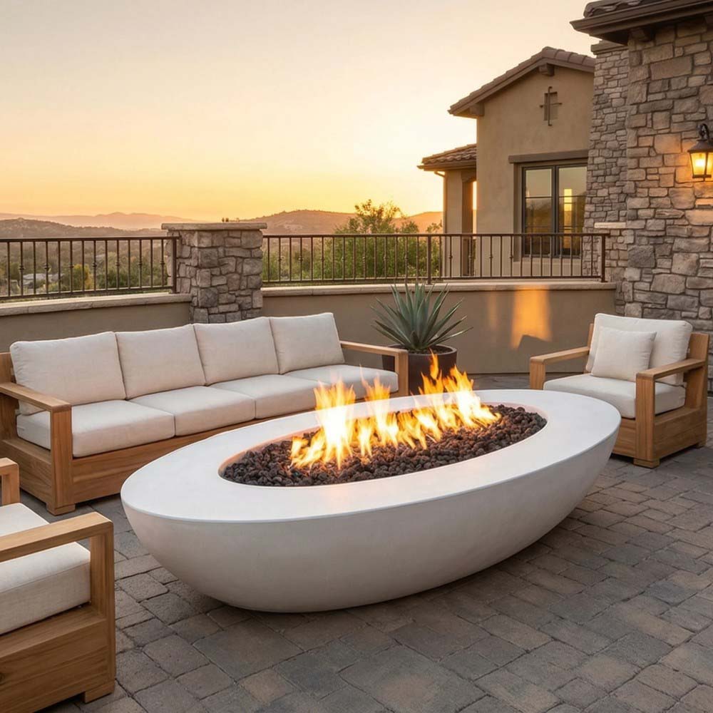 Oval concrete gas fire pit with lit flame and light gray white finish