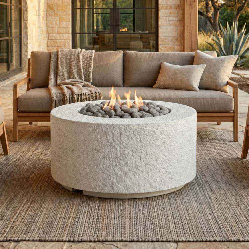 Cylindrical concrete gas fire pit with flame and burner rocks, outdoor patio