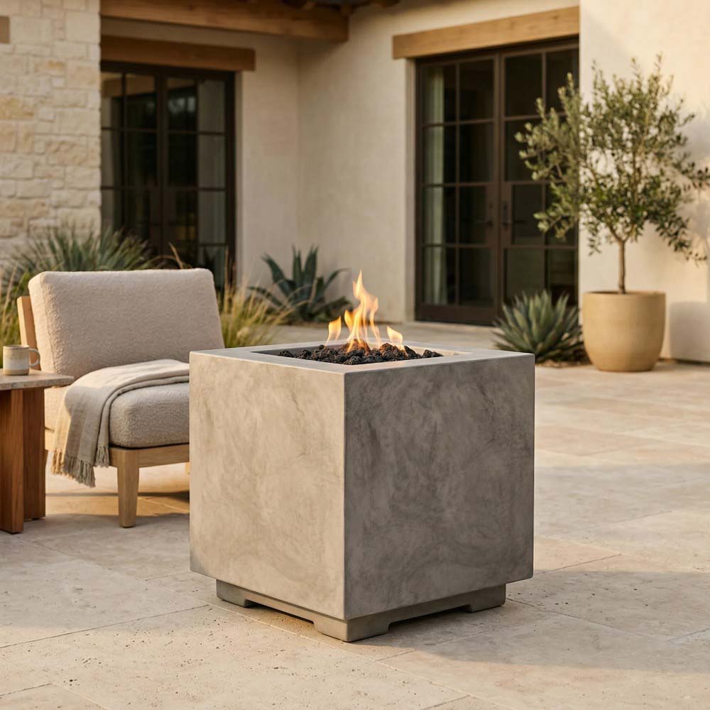 Light gray square concrete gas fire pit with flames burning in the center.