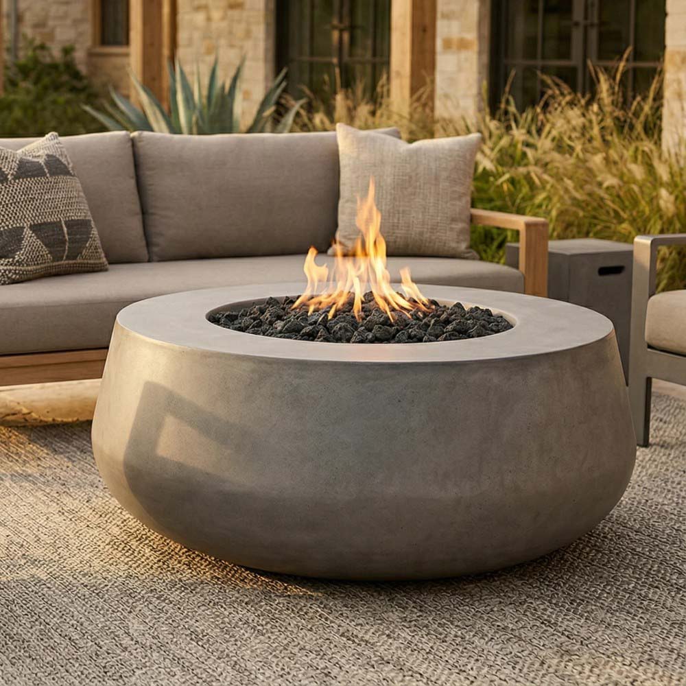 Light gray concrete gas fire bowl with flame rising from black lava rock bed
