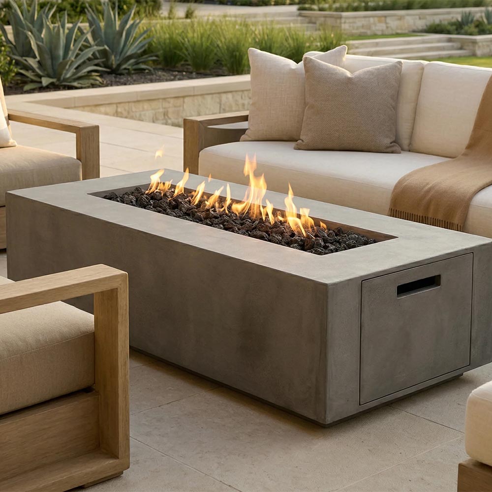 Concrete propane gas fire pit with visible flames and lava rocks on outdoor patio