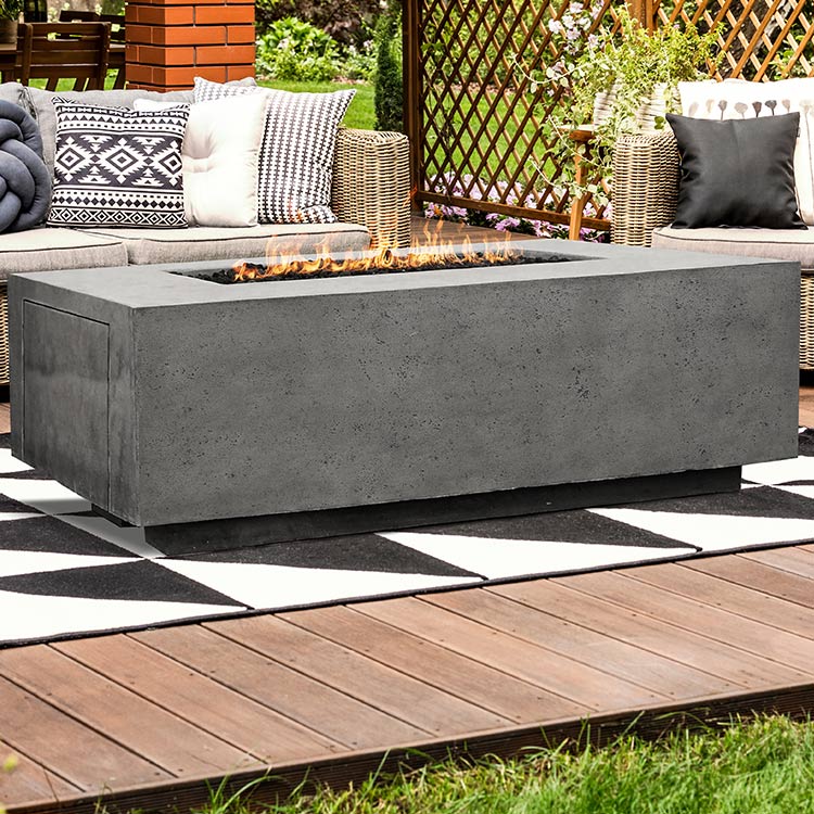 Rectangular concrete gas fire pit with burning flames and wide front firebox opening
