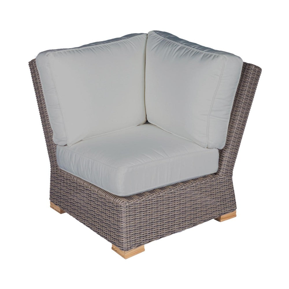 Dark wicker corner chair with light gray seat cushions and curved backrest