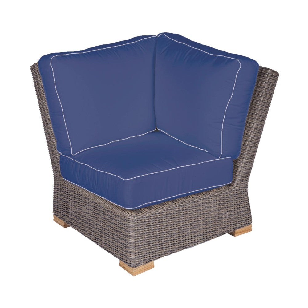 Dark wicker corner chair with navy seat cushions and white piping