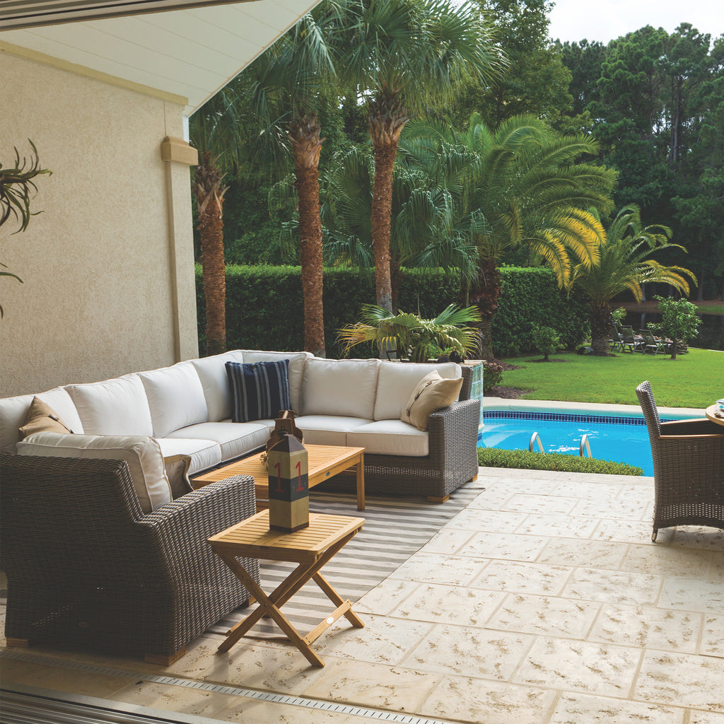 Outdoor sectional set with white cushions and dark gray wicker, arranged on patio