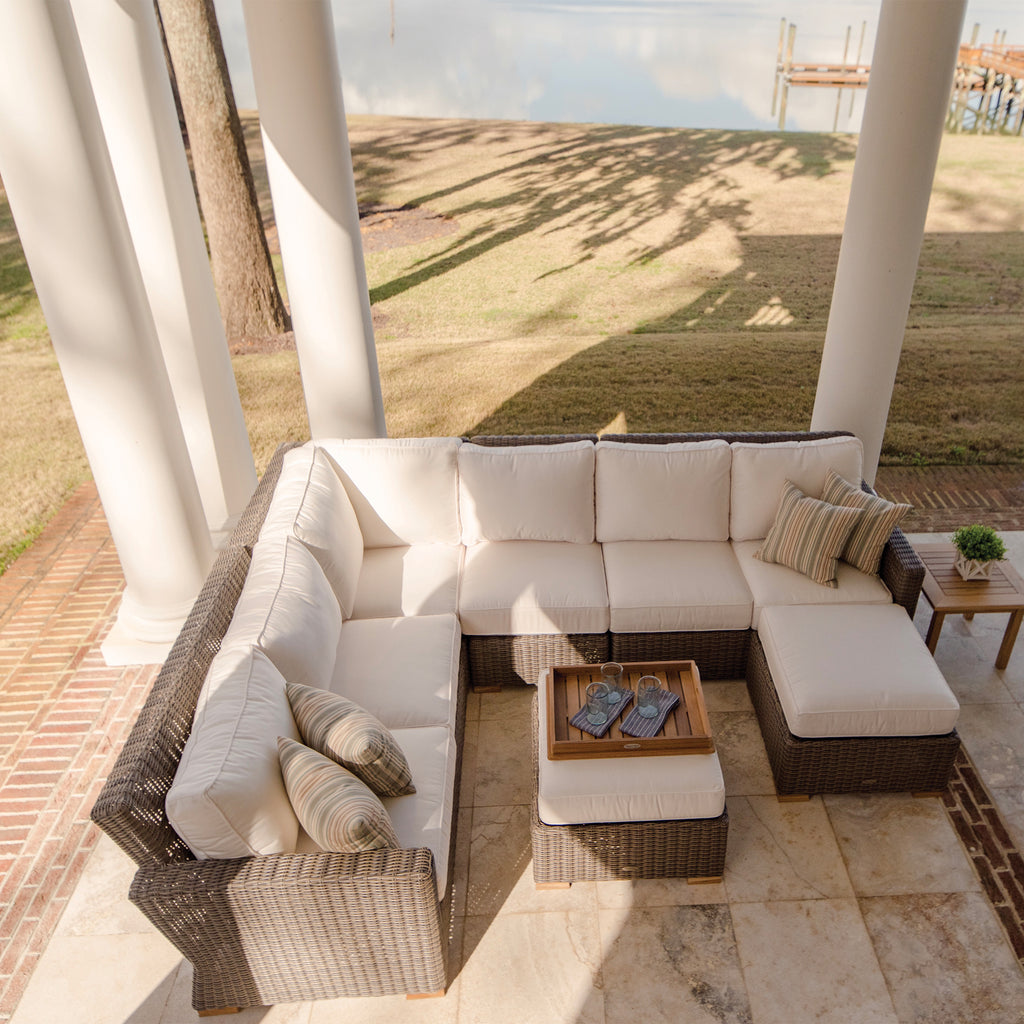 Outdoor sectional set with white cushions and dark gray wicker, corner and seats visible