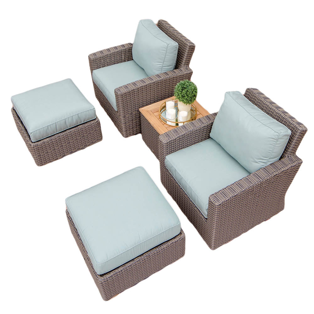Outdoor wicker seating set with light blue cushions, including ottoman and table with drink tray