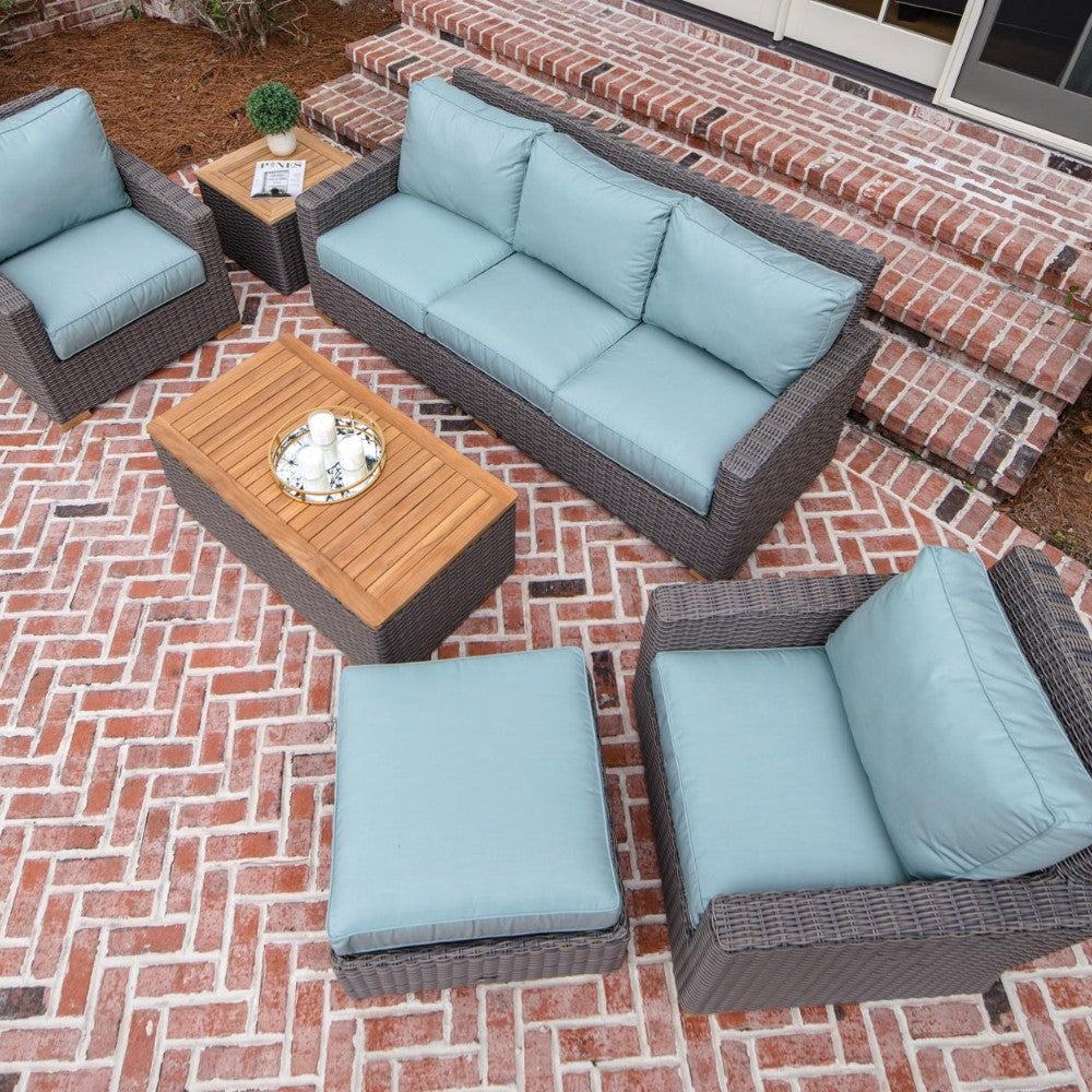 Outdoor patio loveseat sofa with dark wicker frame and light blue cushions
