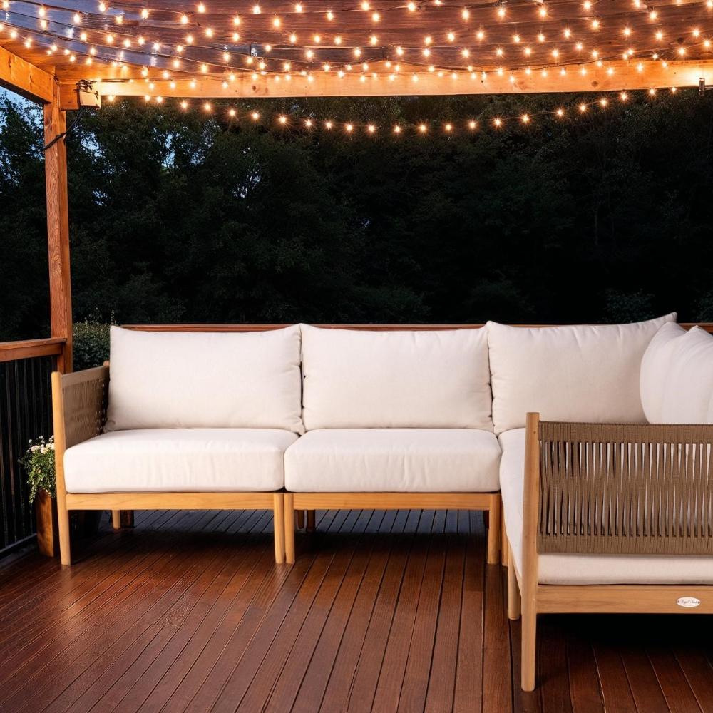 Outdoor sofa sectional with cream cushions, teak arms, and woven gray back, patio view