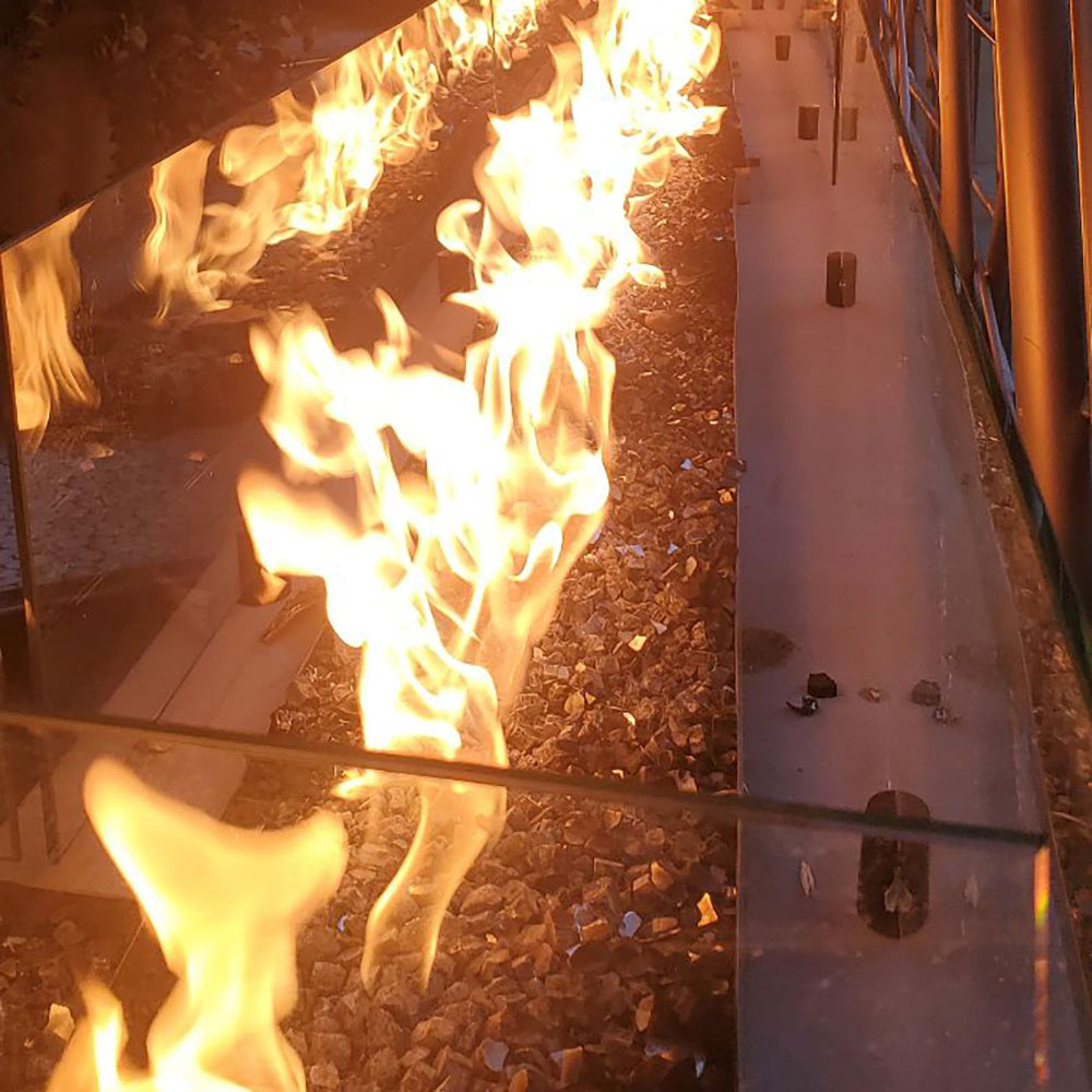 Linear gas fire pit burner with tall flames in the trough channel