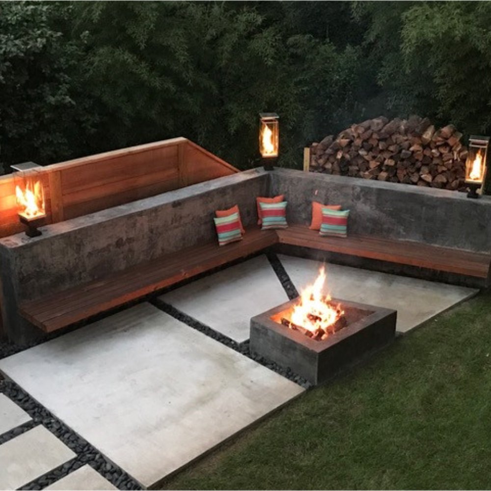 Outdoor gas torch flames in glass enclosures on patio pedestal stands