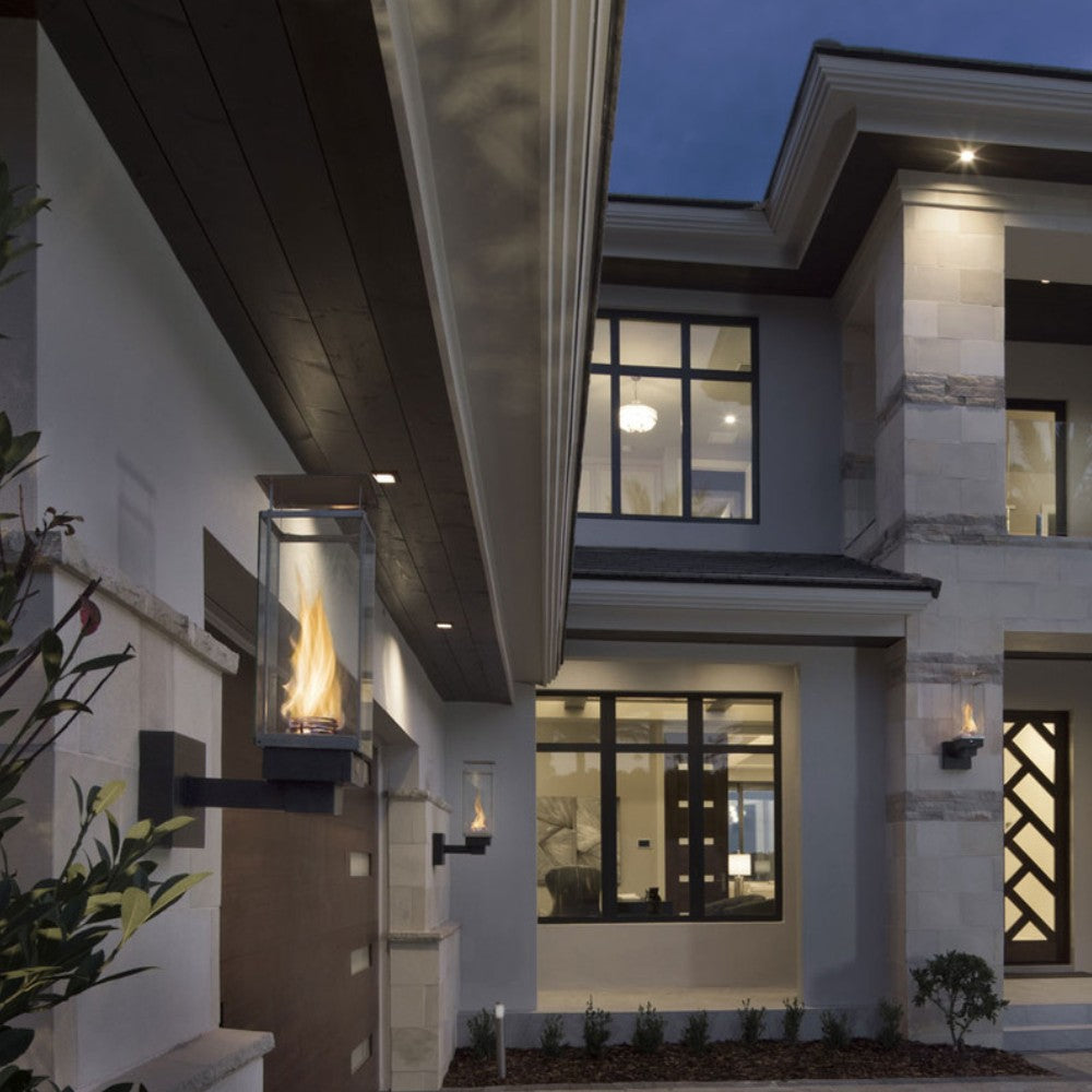 Outdoor wall-mounted gas torch with glass enclosure and active flame
