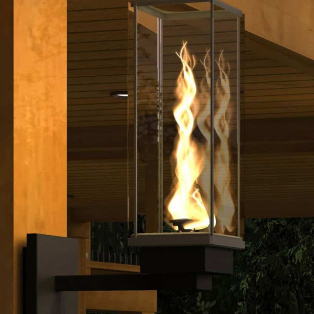 Wall-mounted gas torch with glass burner and flame in outdoor setting