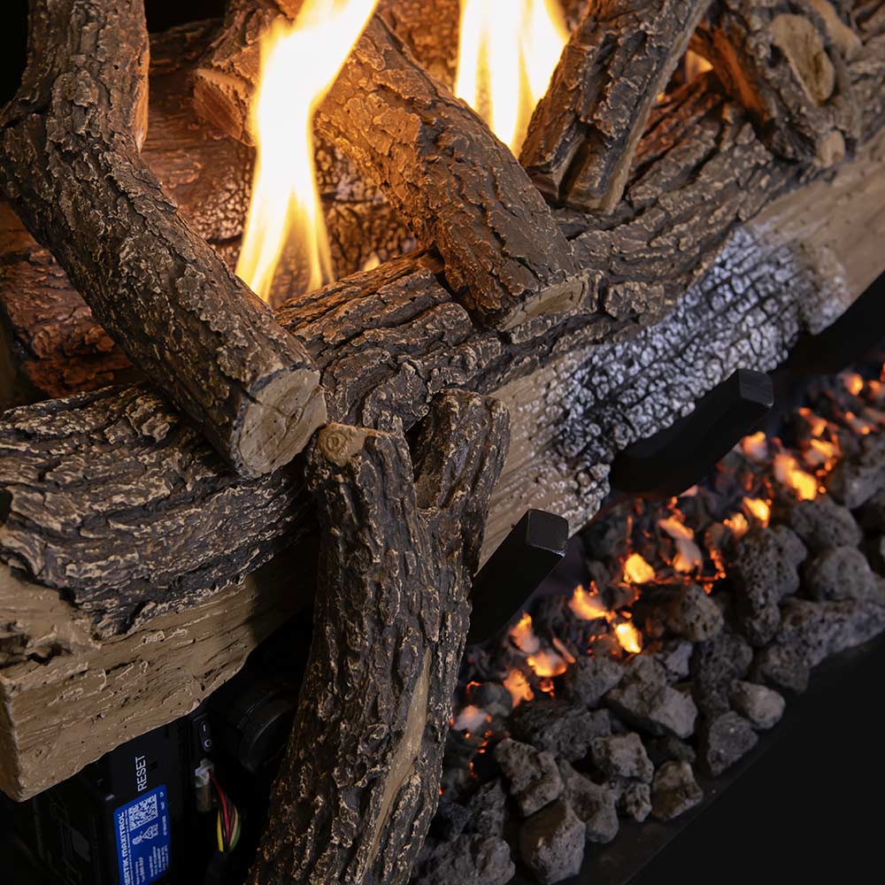 Split oak gas logs with bright flames over a glowing ember bed