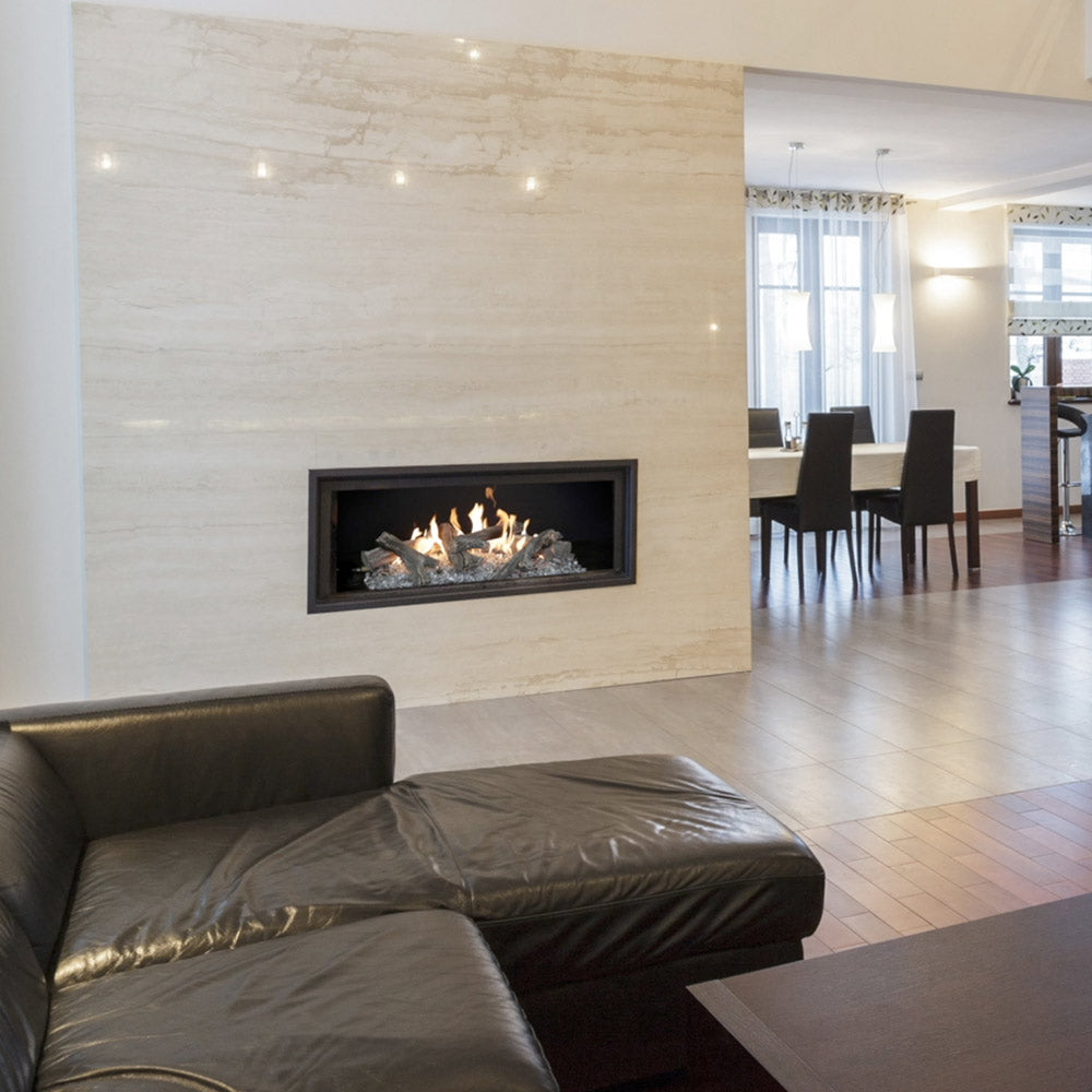 Linear gas log set with driftwood-style logs burning inside a fireplace