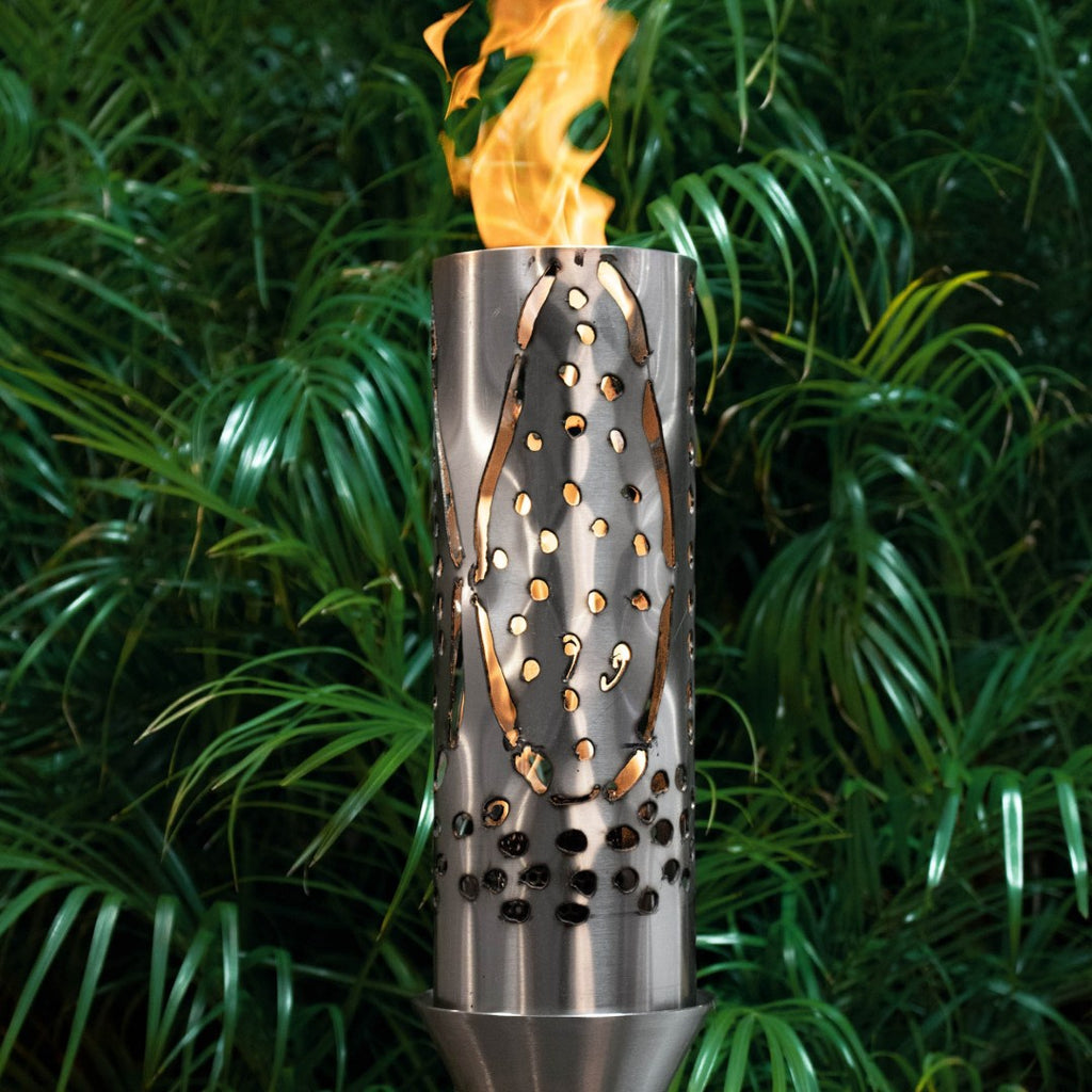 Outdoor flame torch with stainless steel perforated cylinder, open top and burning flame.