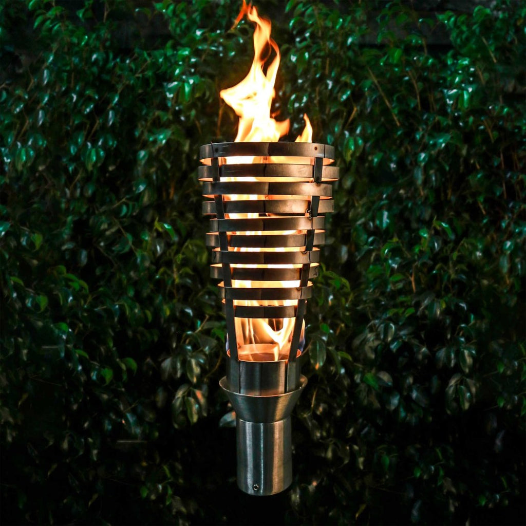 Metal patio torch with flame in cylindrical stand and slatted basket